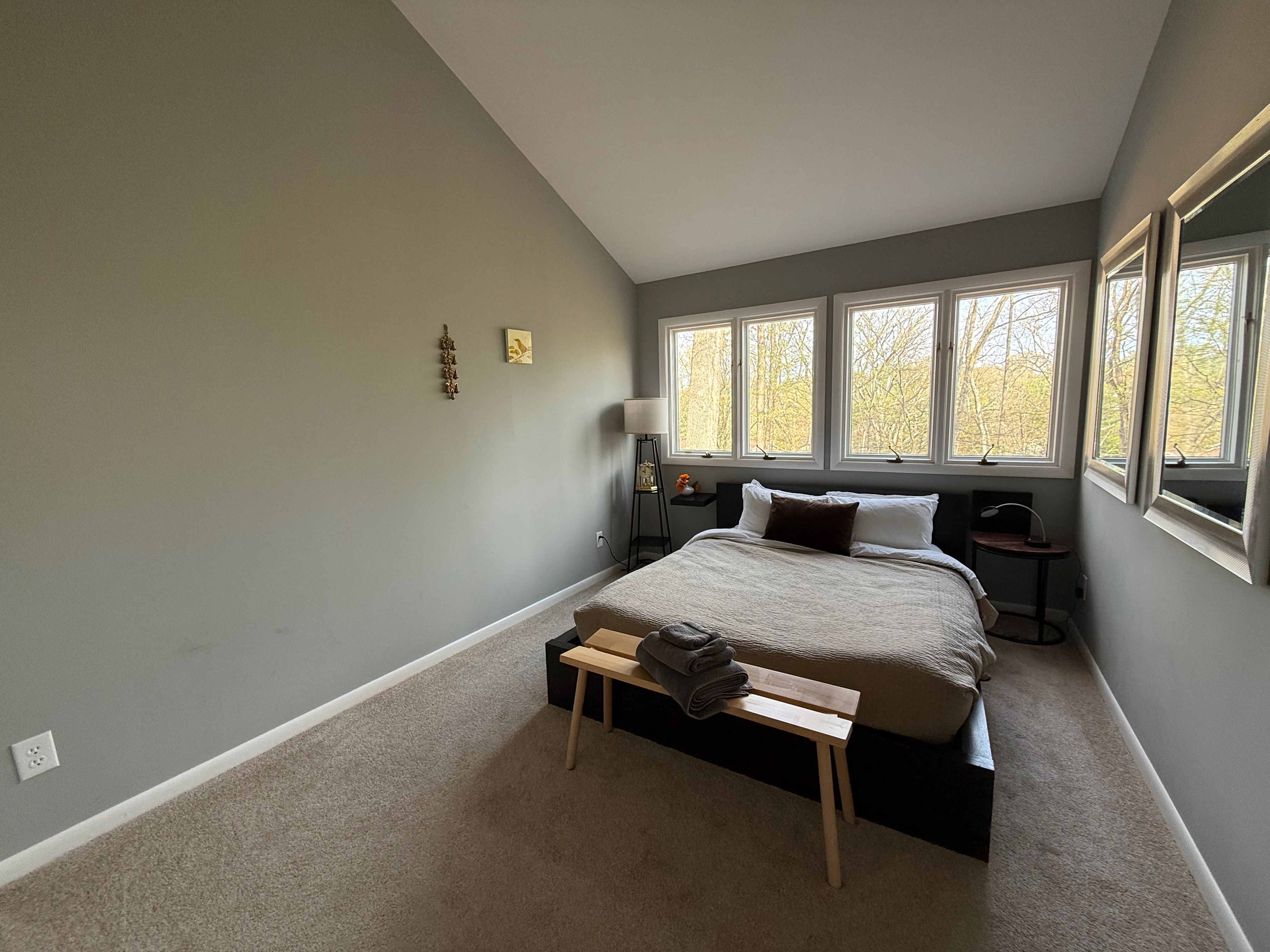 Guest bedroom with queen bed and forest views